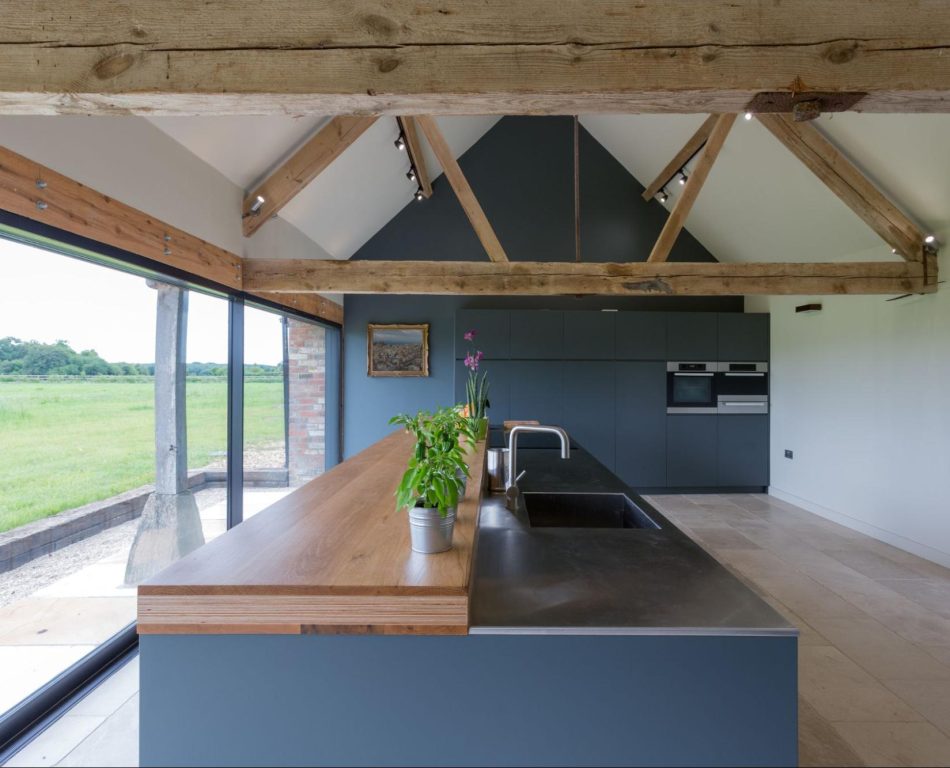 Inside a modern kitchen of a converted barn home with vaulted ceilings.